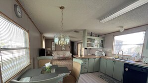 A compact living space with a dining area, kitchenette, and seating area. - Golfing, swimming and a friendly secure community (55+) - SEASONAL (30days+) (North Fort Myers)