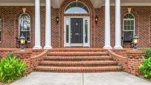 A brick building with a front entrance, white columns, and a set of steps leading up to the door. - Spacious & Private Retreat Near Downtown & NC Zoo! (Asheboro)