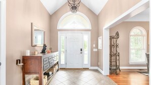 A spacious hallway with a high ceiling, a white door, and a decorative metal rack. - Spacious & Private Retreat Near Downtown & NC Zoo! (Asheboro)