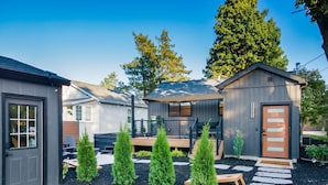 Une propriété résidentielle comprenant un garage, une véranda et un petit abri de jardin.