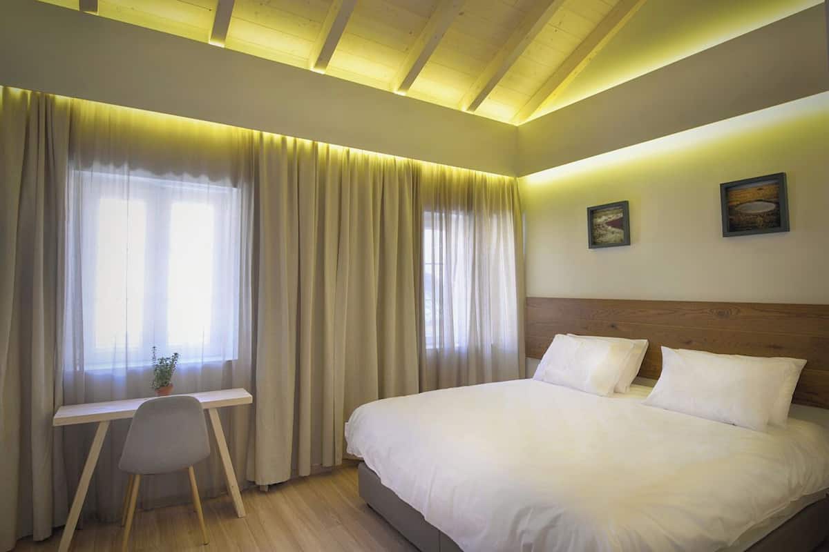 A bedroom with a bed, a desk, and a chair.