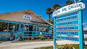 A coastal art gallery with a sign listing services like glass garage, pottery, art glass, wildlife art, and local artists. - Private Crystal River Getaway Minutes to Springs! (Crystal River)