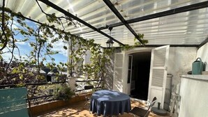 A covered patio with a table and chairs, a pergola with vines, and a view of the surrounding area. - Charming T2 near beach of Trouville-sur-Mer (Trouville-sur-Mer)