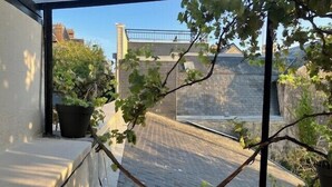 A view from a window overlooking a brick pathway and a building with a metal railing. - Charming T2 near beach of Trouville-sur-Mer (Trouville-sur-Mer)