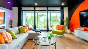 A modern living room with a sofa, armchairs, a coffee table, and a TV. - Queen s Gambit - 7 min Uber to Downtown ATX (Austin)