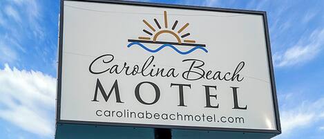 A motel sign with the name "Carolina Beach Motel" and a website address.