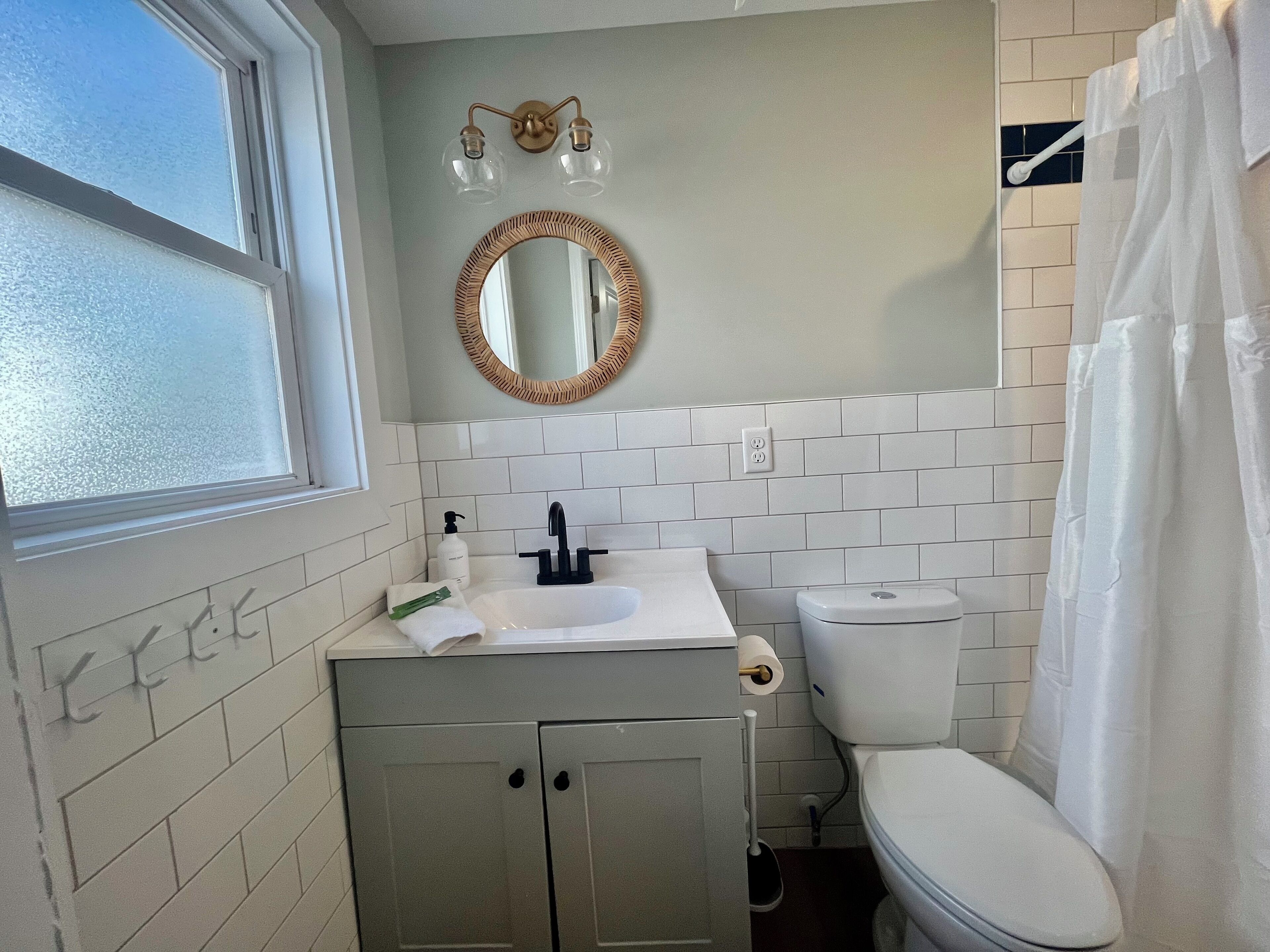 A bathroom with a white sink, a mirror, and a toilet.