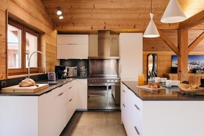 Una cocina moderna con paredes de madera, electrodomésticos de acero inoxidable y una isla central con asientos.