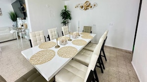 A dining area with a white table, beige chairs, and decorative placemats.