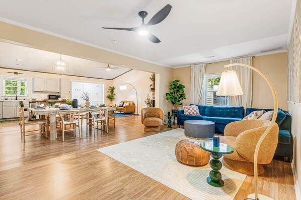 Ein großzügiger Wohnbereich mit Esstisch, Sofas und einer Küche im Hintergrund.