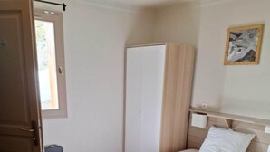 A bedroom with a bed, a wardrobe, a bedside table, and a window. - 100m from ski slopes, 2nd floor, balcony, fireplace or stove, tv, ski locker, 64m², Val Thorens (Val Thorens)