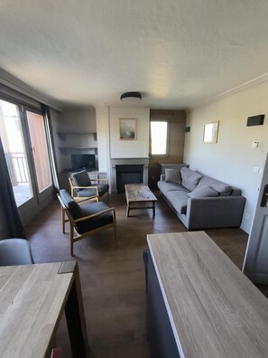 A spacious living room with a sofa, chairs, a coffee table, and a fireplace.