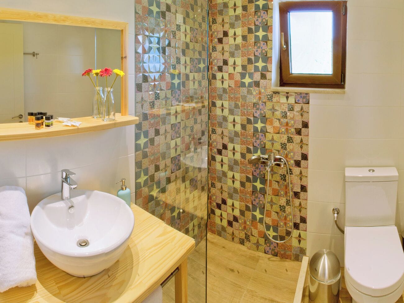 A bathroom with a white sink, a glass shower enclosure, and a toilet.