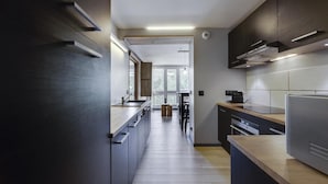 A modern kitchen with dark cabinetry, a central island, and a view to the dining area. - 200m from ski slopes, 5th floor, balcony, tv, 43m², Les Arcs (Les Arcs)