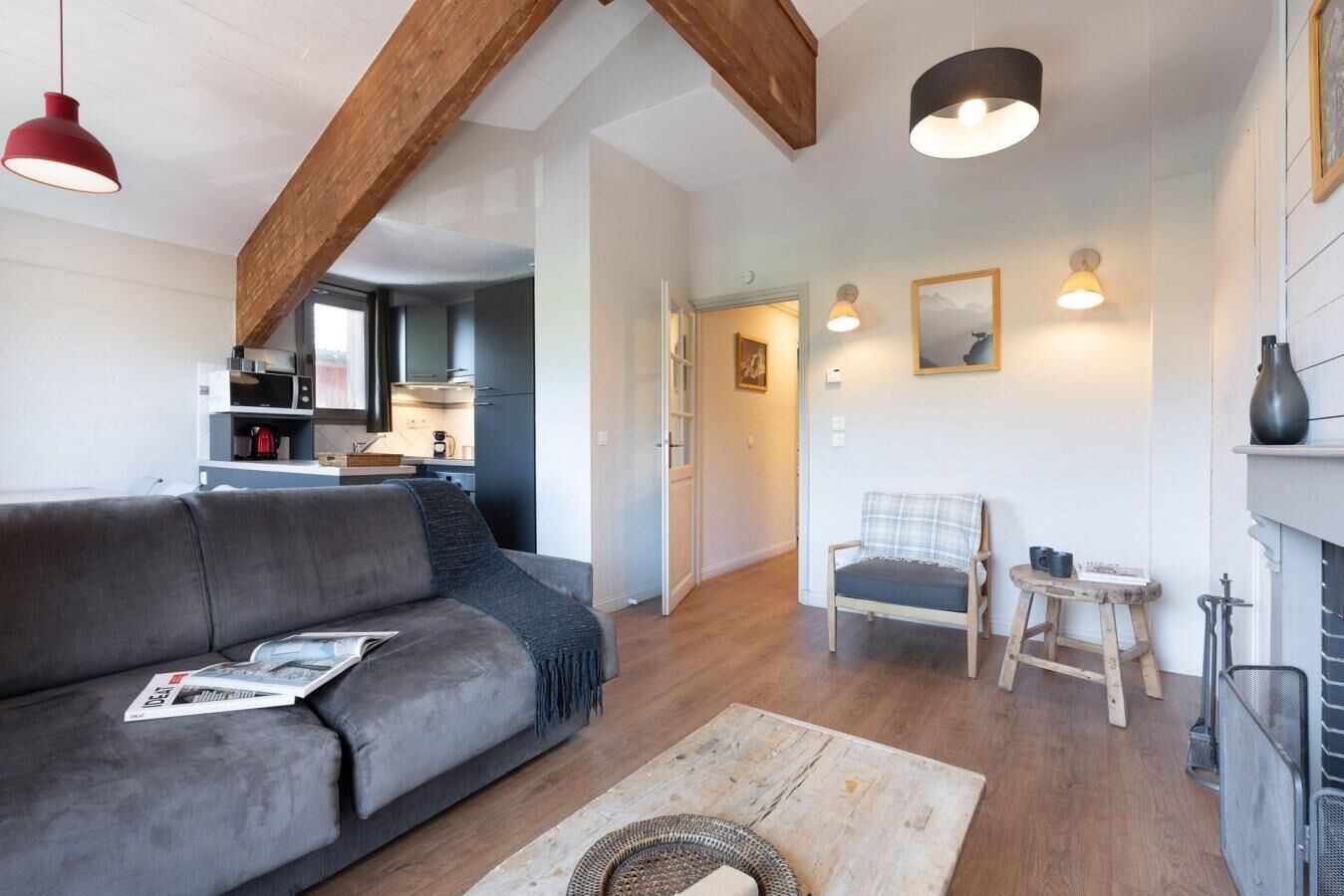 Ein gemütliches Wohnzimmer mit grauem Sofa, einem Holztisch und einem Kamin.