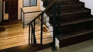 A staircase with dark wooden steps and black metal railings, leading to an upper level. - Surendra Seaview (Matara)