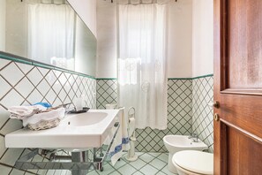 A bathroom with a sink, toilet, and bathtub. - Terrazze sullo Ionio by BarbarHouse (Santa Caterina)