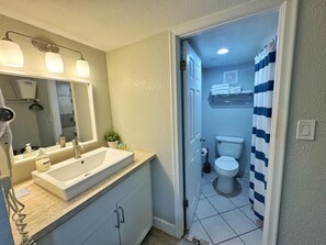 A bathroom with a sink, mirror, and toilet.