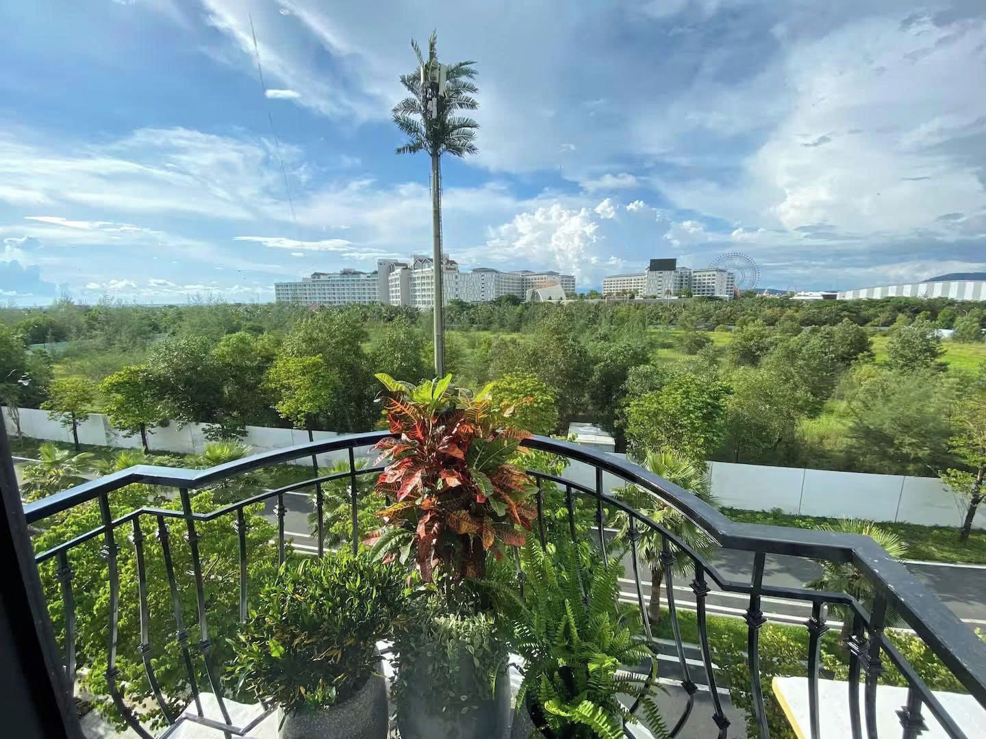 Ein Balkon mit Blick auf eine Stadtlandschaft, einschließlich Gebäude und einem Riesenrad.
