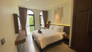 A modern bedroom with a large bed, a bedside table, a mirror, and a wardrobe.