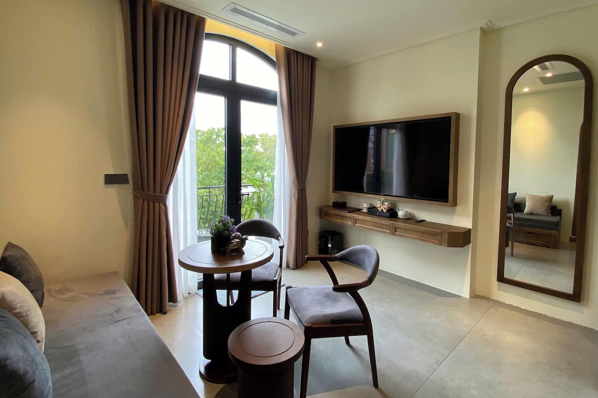Suite – deluxe, balkong, hageutsikt | Oppholdsområde | En 65-tommers smart-TV med digitale kanaler