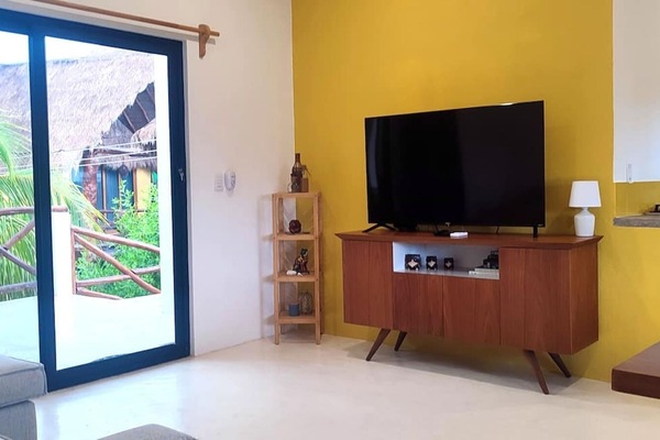 Living room with a view of the terrace, featuring a comfortable sofa and a Smart TV.