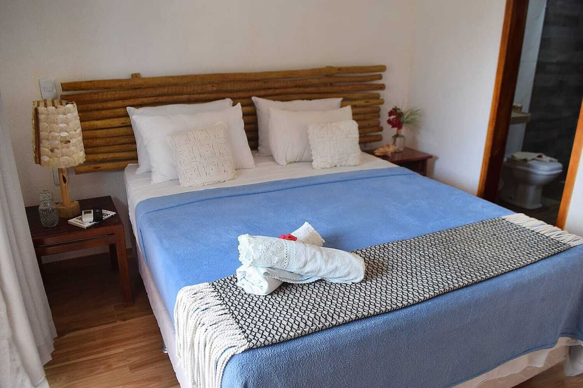 Ein Hotelzimmer mit einem hölzernen Kopfteil, einer blauen Bettdecke und weißen Kissen.