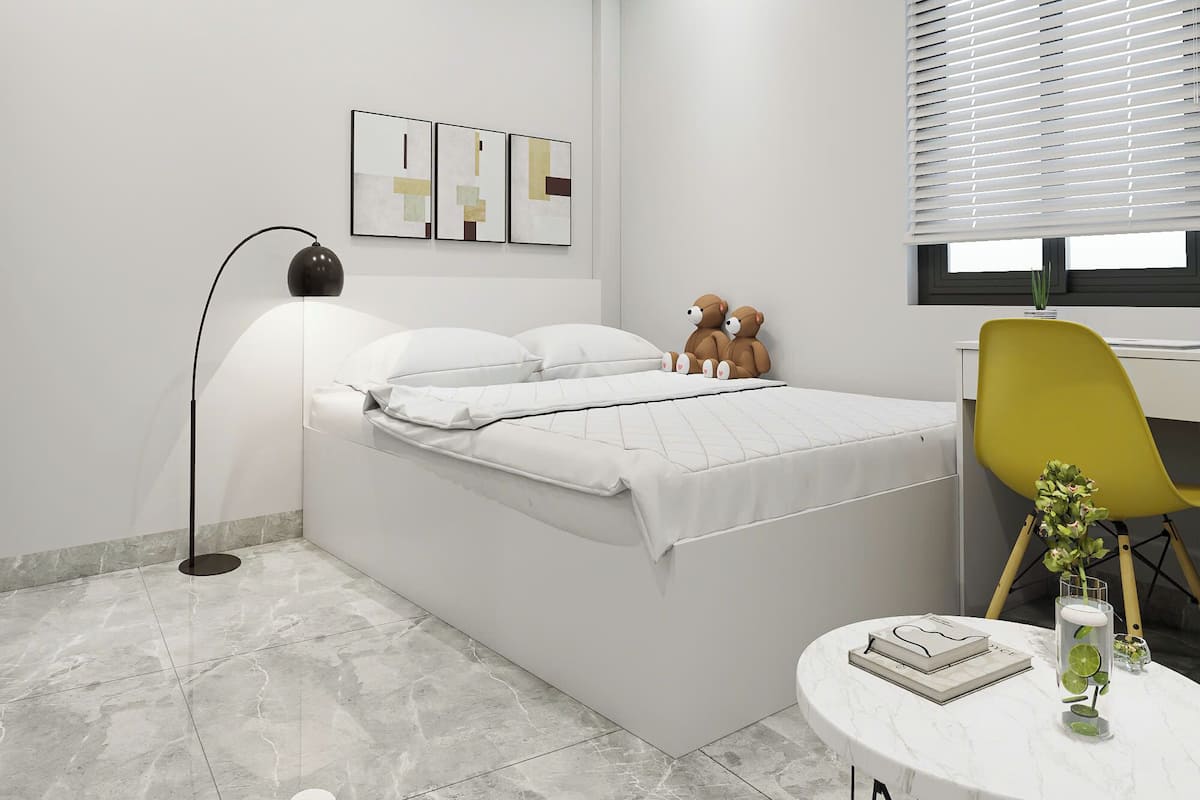 Ein modernes Schlafzimmer mit Bett, Schreibtisch, Stuhl, Stehlampe und Bildern an der Wand.