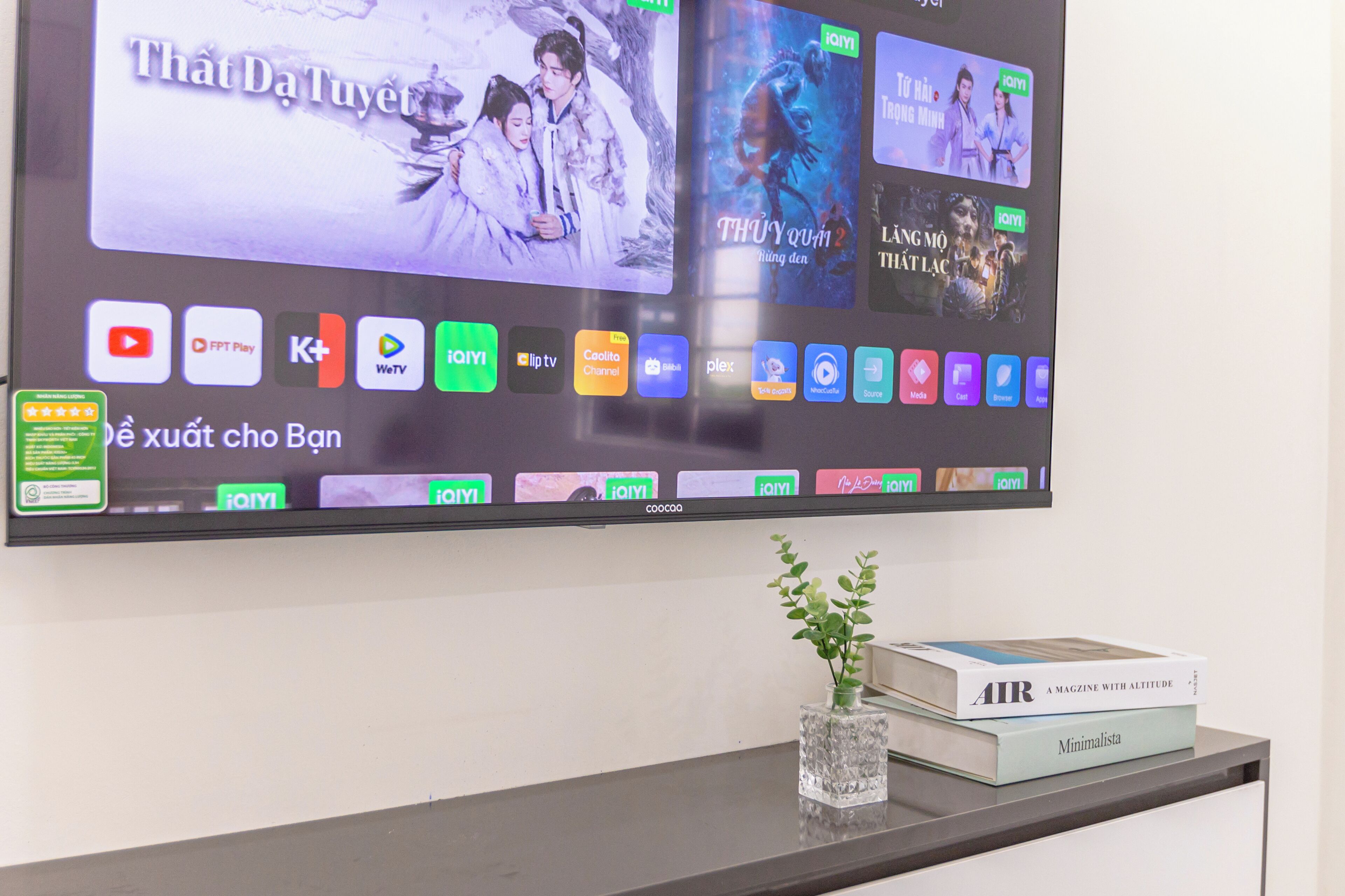Ein flachbildfernseher an der Wand, der verschiedene Streaming-Apps und eine Auswahl an Filmen zeigt.