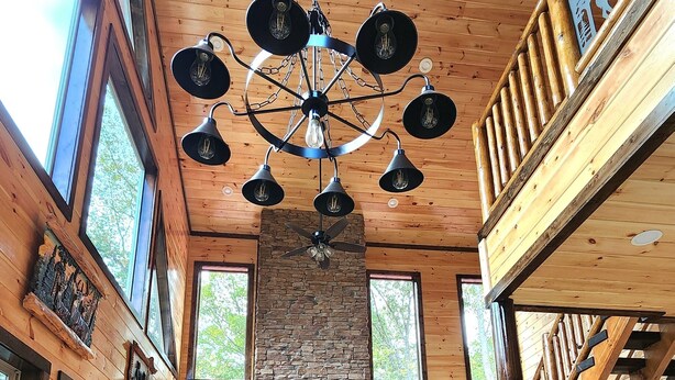 Ein Holzinnenraum mit einem für eine Mahlzeit gedecktem Esstisch, einem Kamin und einer Chandelier.