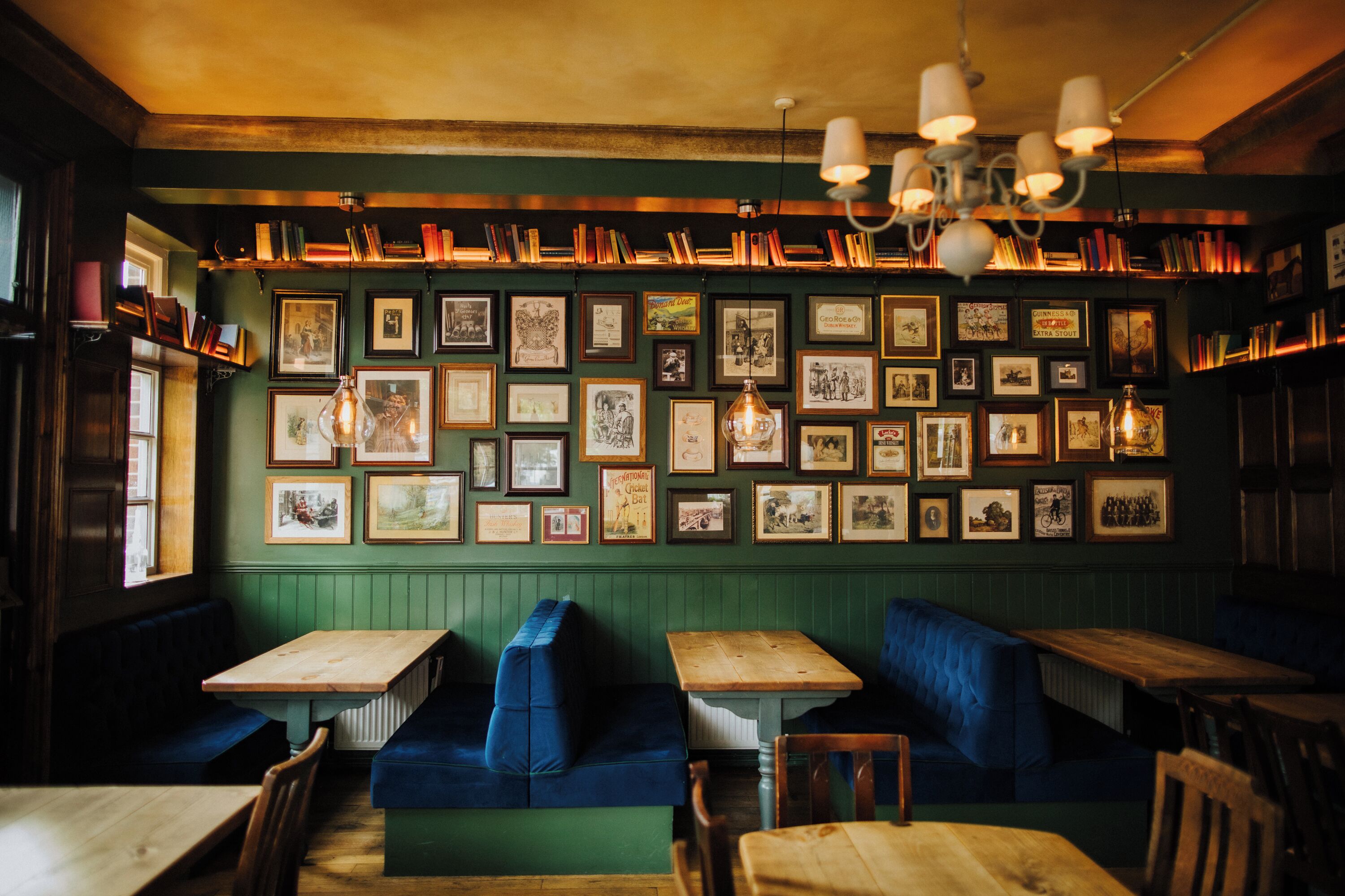 Un restaurante acogedor con mesas de madera y cabinas azules, fotografías enmarcadas en las paredes y un ambiente cálido y agradable.