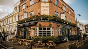 Un edificio en esquina con un cartel que dice "The Hanbury Arms Free House".
