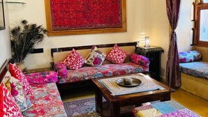 A traditional living room with a sofa set, a coffee table, and a patterned rug.