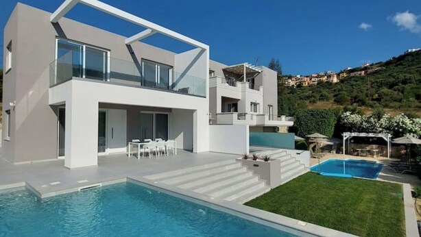 A modern two-story house with a swimming pool and a patio area. - Luxury Villa (Chania)