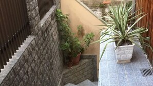 Un escalier recouvert de carreaux gris menant à un niveau supérieur.