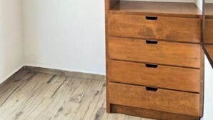 Un dressing avec des étagères et des tiroirs en bois.