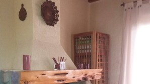 A stone fireplace with a wooden mantel, a stone wall, and a tiled floor. - Cerro Catedral excellent studio apartment (Cerro catedral,Río Negro Province)