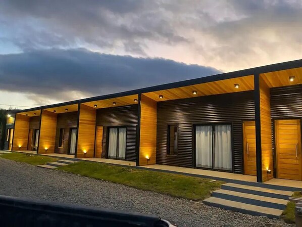 Un hotel moderno con varias habitaciones que presentan paneles de madera y ventanas amplias.