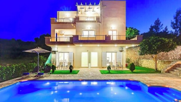 Un immeuble à plusieurs étages avec une piscine devant.