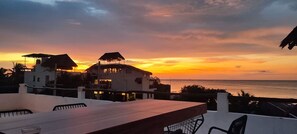Propiedad frente al mar con comedor y vistas al océano, que incluye una mesa grande y sillas.