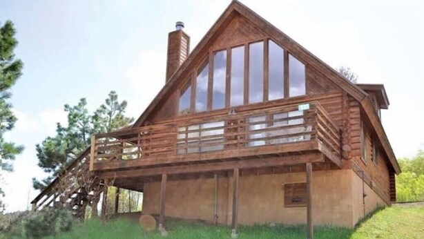 A wooden cabin with a balcony, large windows, and a chimney. - Angel Fire | Ski Weekend Stay | Hot Tub & Mountain (Angel Fire)
