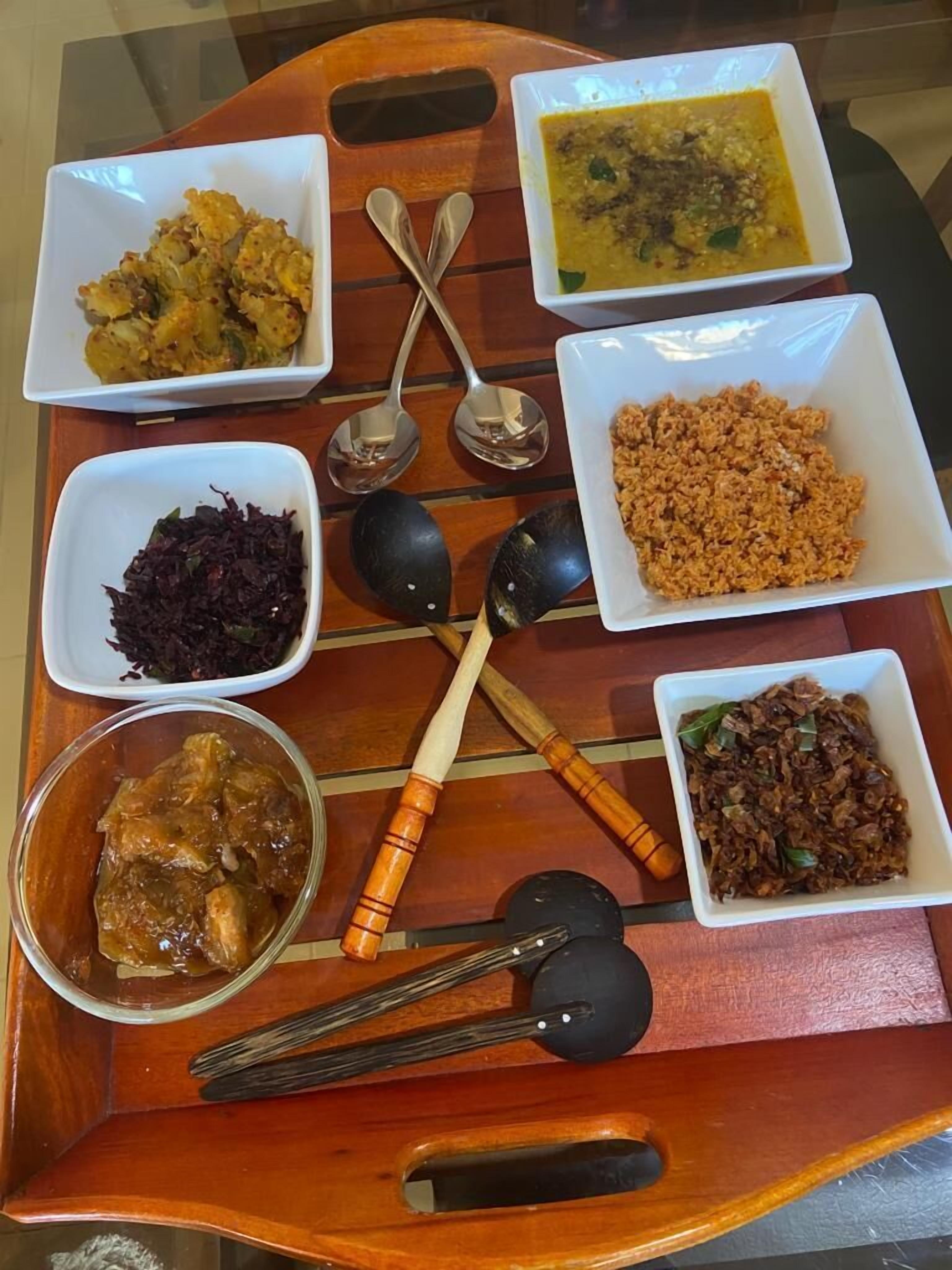 A wooden tray with various dishes and utensils.