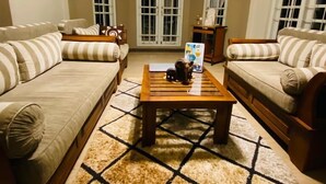A living room with two sofas, a coffee table, and a patterned rug. - VISTA HOUSE (Kandy)