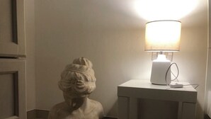 A white bust sculpture on the floor next to a white table with a lamp. - Charming 1-bedroom apartment with WiFi, AC in amazing Bari (Bari)