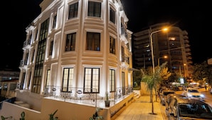 A multi-story building with balconies and large windows, surrounded by parked cars and streetlights. - The Collector hotel boutique (Sarandë)