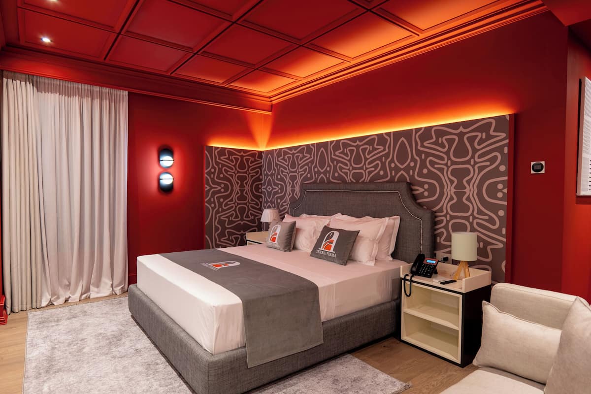 A modern bedroom with a large bed, bedside tables, and a nightstand.