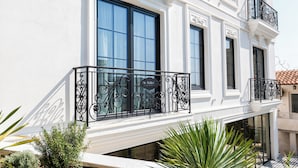 A white building with large windows and a balcony with black wrought iron railings. - The Collector hotel boutique (Sarandë)