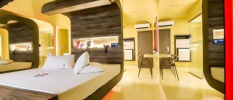 Una habitación de hotel moderna con una cama grande, un área de comedor y un baño.