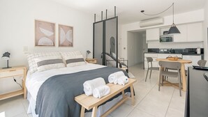 A modern hotel room with a bed, bedside tables, a desk, and a kitchenette. - Comfortable stylish studio in Recoleta (Ciudad Autonoma de Buenos Aires)