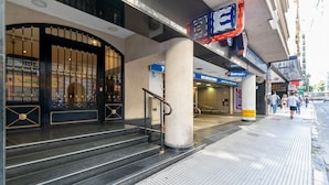 A hotel entrance with a black gate, a staircase, and a sign for 'Entrada'.